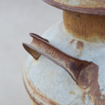 Vintage Milk Can with charming farm imprints and rusty handles.